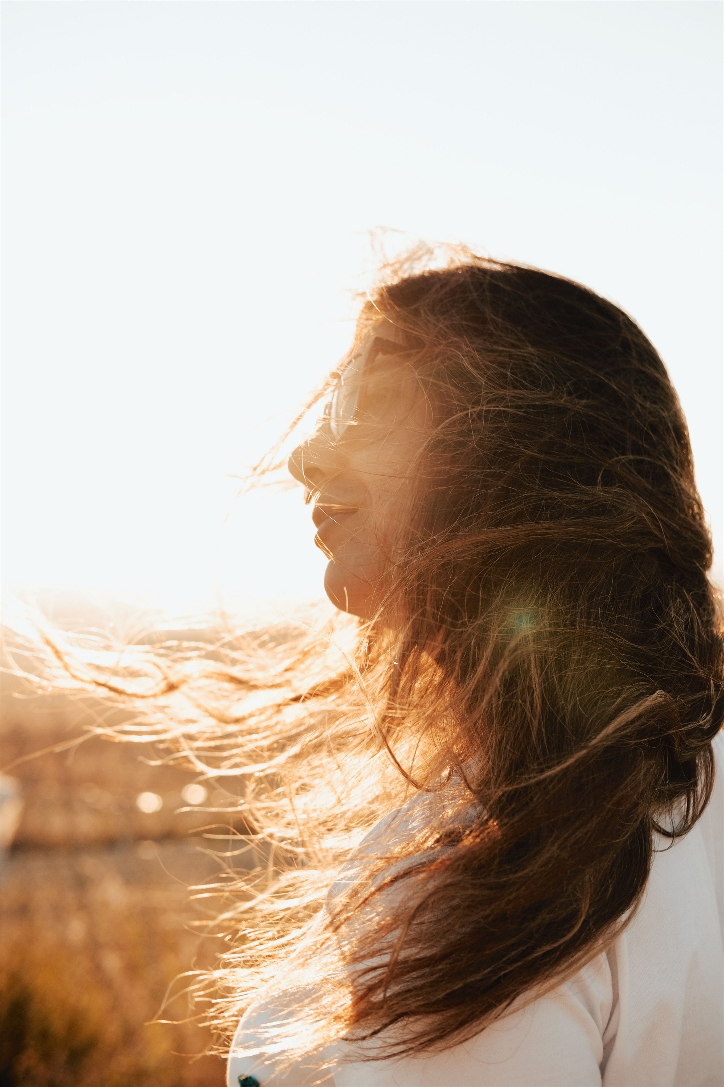 Woman with sun-lit hair in the breeze